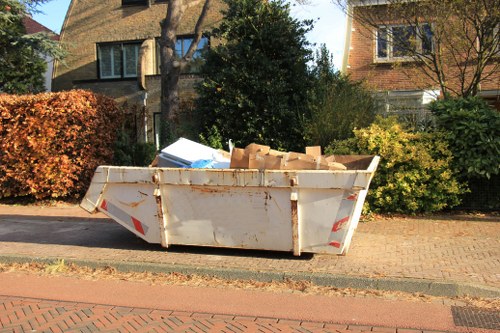Technician removing garden waste in Alperton