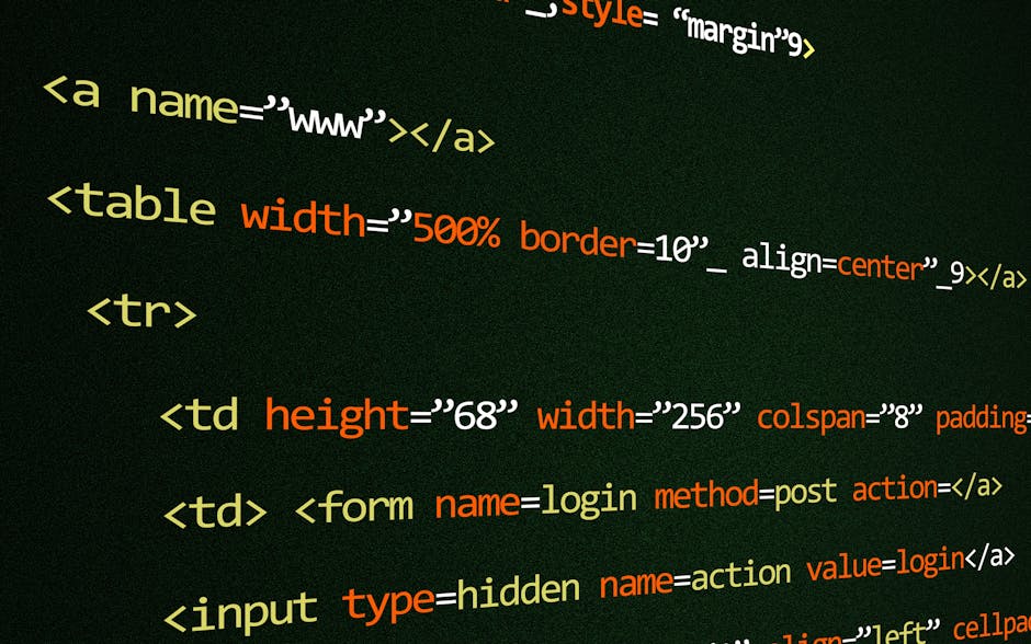 A person wearing a light blue shirt is seated at a desk working on a laptop that displays lines of colorful programming code on the screen. The desk is positioned in a modern office environment, with 
